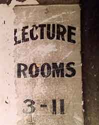 battered lecture room sign
